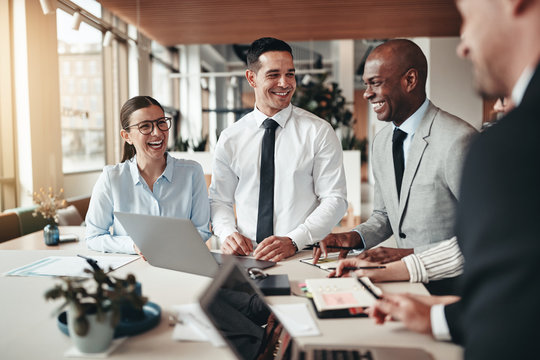Diverse group of businesspeople laughing together in an office