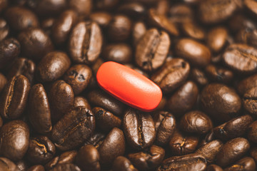pill on the background of coffee beans.
