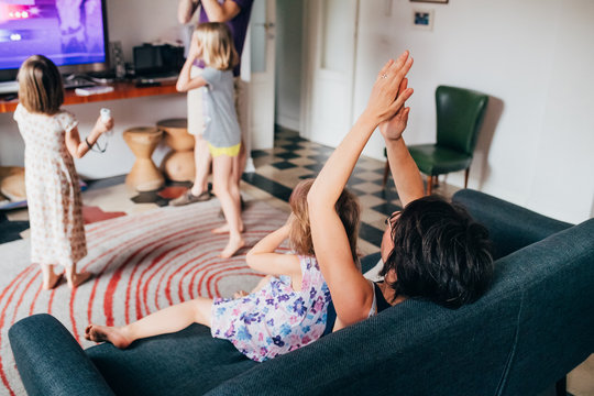 Mother and child celebrating victory of videogames lying on couch