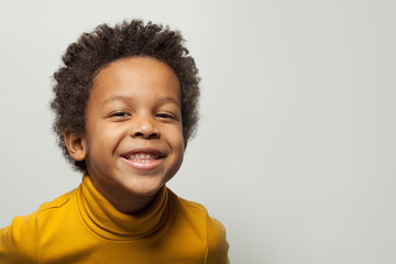 Funny black kid boy laughing on white background