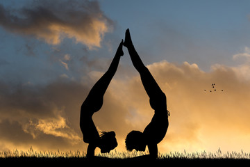 Plakat girl and man do yoga together at sunset