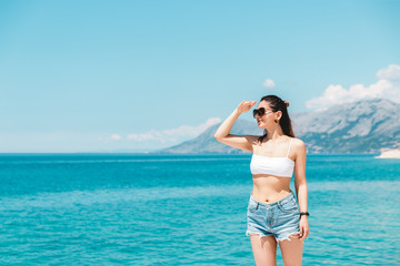Fototapeta na wymiar beautiful young woman traveler enjoying beautiful blue sea view scenery. travel background with copy space