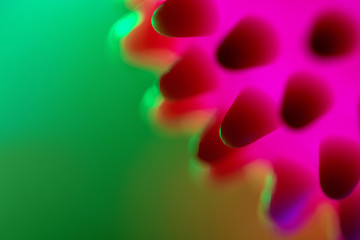 Close-up of a red-pink bacterium floating in a green liquid. Chinese Coronavirus. Blurred green...