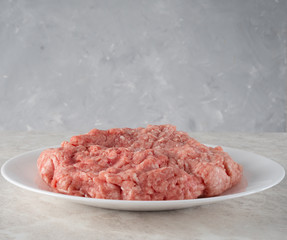 natural fresh minced meat on a white plate.