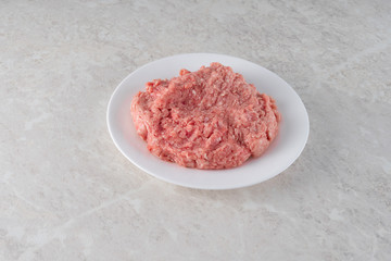 natural fresh minced meat on a white plate.