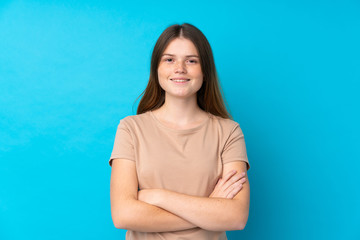 Ukrainian teenager girl over isolated blue background keeping the arms crossed in frontal position