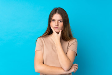 Ukrainian teenager girl over isolated blue background thinking