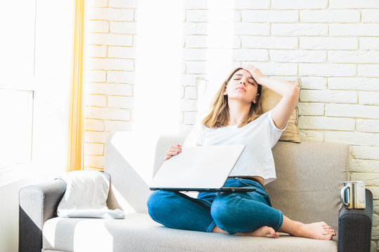 young attractive woman at home tiredly seeking for a job or rent in internet