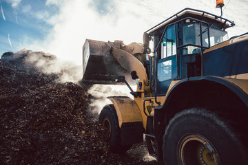 Earth mover working on pile of compost - obrazy, fototapety, plakaty