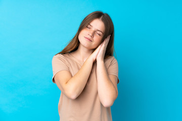 Ukrainian teenager girl over isolated blue background making sleep gesture in dorable expression