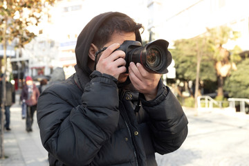 Young photographer taking photos on the streets of the city