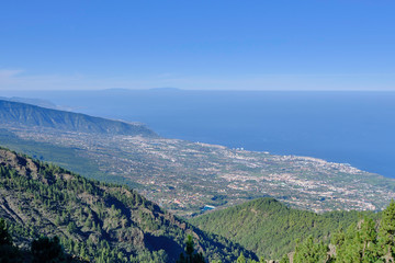 Scenic aerial view of small town on Tenerife island on Canary islands in Spain. Beautiful summer sunny look of Atlantic ocean, coastline and mountains on tropical paradise island near Africa