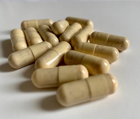 White medical pills or candy on light blue background.