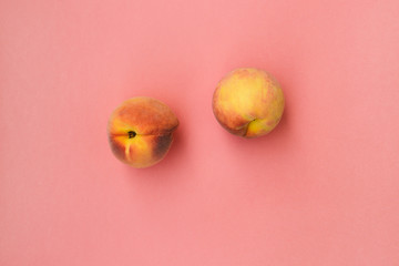 Sweet juicy peaches on a pink layer. Fresh summer fruit. Flat lay, top view.