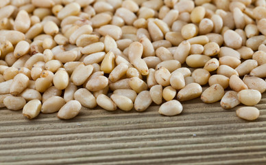 Pile of delicious pine nuts on a wooden surface