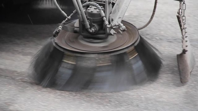 Street sweeper spraying water and cleaning street - Extreme close up