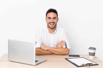 Young business man with a mobile phone in a workplace with surprise facial expression