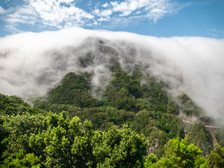 Amazing landscape of clouds floating down from high mountain and covering jungle forest