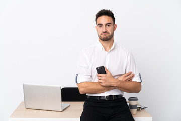 Young business man with a mobile phone in a workplace sad