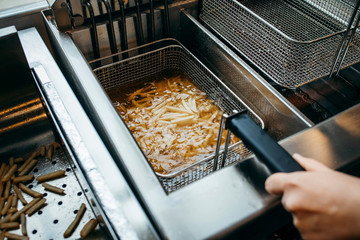 Deep fryer for potatoes in kitchen