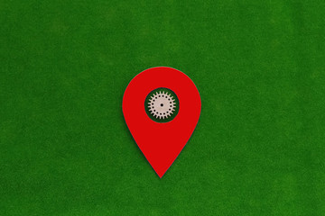 Red navigation sign with a wooden gear on a green background. Location.