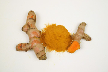 Turmeric powder and turmeric root extracts on a white background are used as a tonic for the body and food ingredients.