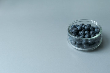Delicious transparent glass bowl of fresh organic blueberries on a modern kitchen countertop
