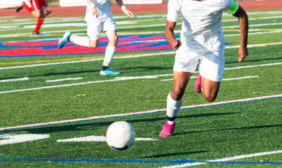 Soccer player chasing the ball down the field