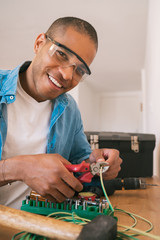 Latin man fixing electricity problem at home.