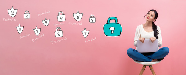 Cyber security theme with young woman using a laptop computer