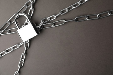 Steel padlock, chains and space for text on grey background, flat lay. Safety concept