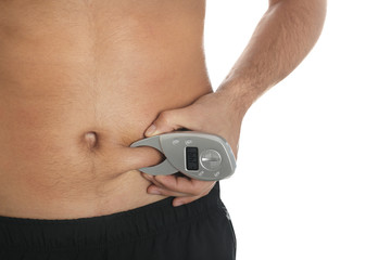 Man measuring body fat layer with digital caliper on white background, closeup. Nutritionist's tool
