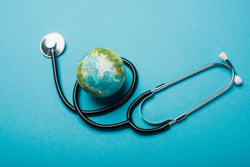 Globe and stethoscope on blue background, world health day concept - obrazy, fototapety, plakaty