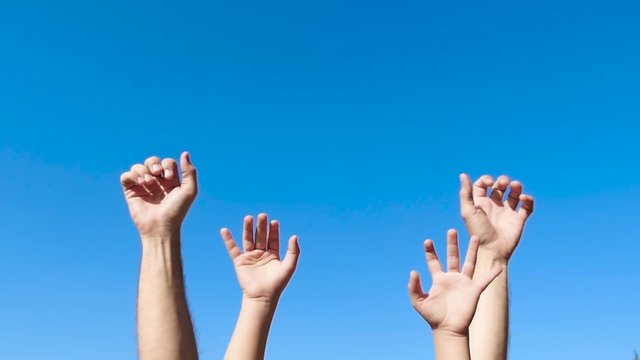 Men's hands and small children's hands close-up against the blue sky. Gestures.