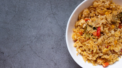 Large white deep bowl with pilaf. Rice with vegetables. National cuisine. dark background. Top view with place for text.