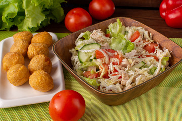 Fresh vegetable salad with nuggets. Still-life. Wooden table. Greens and vegetables.