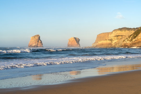 Beach of Hendaye with the two brothers rocks in the background at golden hour. Basque Country of France.
