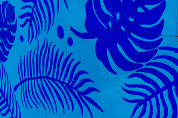 Fototapeta na wymiar Palm Tropical Leaves painted on Blue wall.