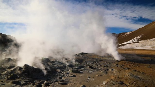 Namafjall Hverir geothermal area in Iceland. Stunning landscape of sulfur valley with smoking fumaroles and blue cloudy sky, travel background, tourist attraction