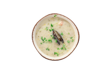 Garlic cream soup with mussel and micro greens in grey bowl isolated on white background