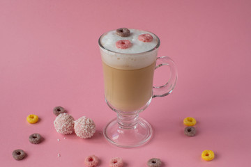 Cappuccino in a glass with bright colorful candies. still-life. coffee.