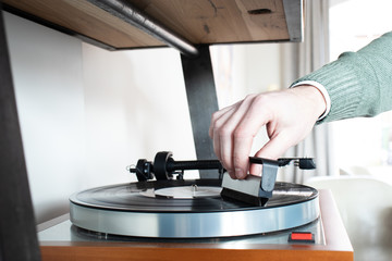 man is using an anti static vinyl brush on a record music player. Cleaning lp