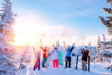 Group of snowboarders and skier dawn with snowboards rejoice snow Light sun in winter forest...