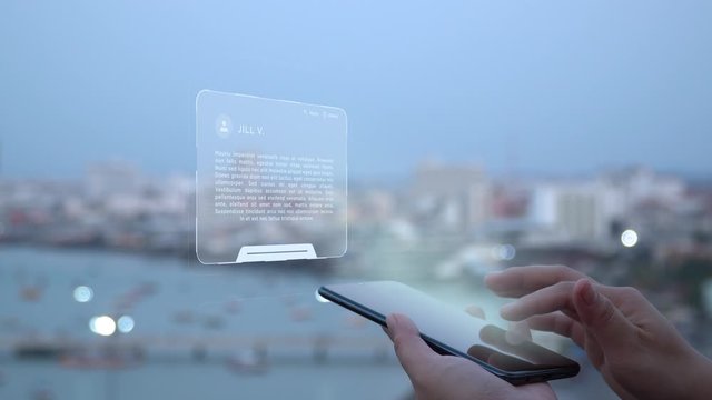 Female hands on the view point of city with a HUD hologram with email aplication. Woman uses the holographic technology of the future in the smartphone screen on the background of the evening city.