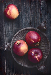 red apples on old dark rustic wooden table surface, flatlay
