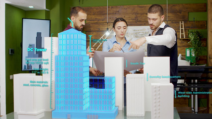 Team of architects working on city skyscrapers using augmented reality holograms