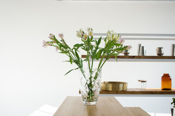 The interior of a bright kitchen. Kitchen interior design. Vase of flowers on the table in the kitchen.