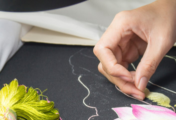 girl embroiders silk thread cloth