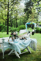 Catering for a wedding in the forest. Festive table of the newlyweds.