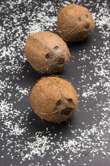 Three coconuts and coconut flakes
